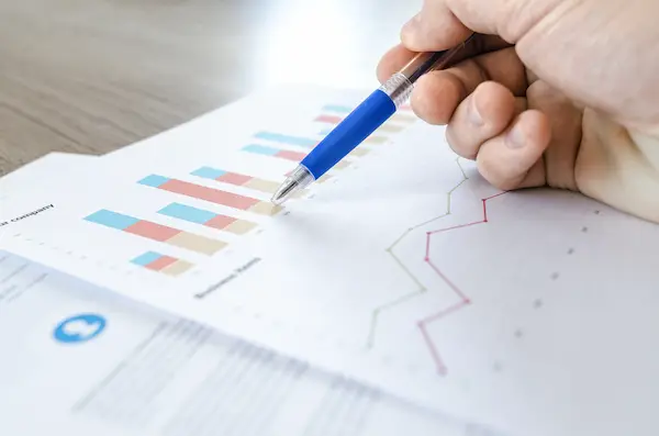 hand holding pen above data chart